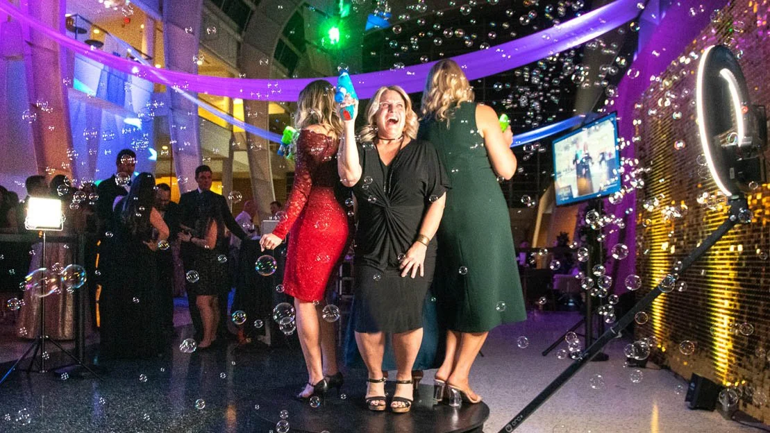 360 photo booth platform with red carpet and LED lighting set up under a marquee at an event